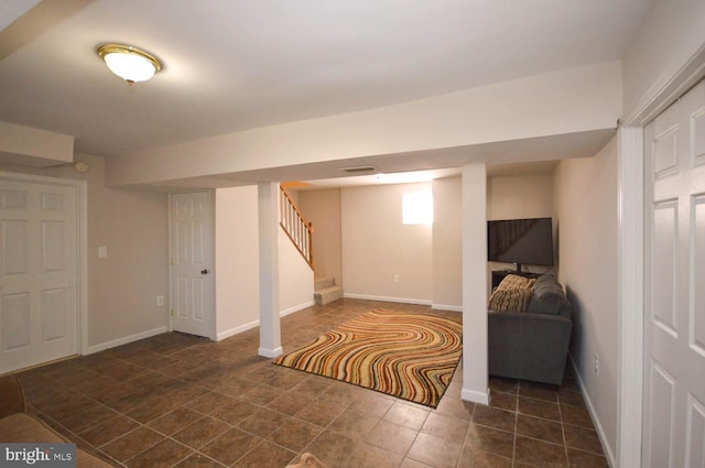 below grade area featuring visible vents, stairway, and baseboards