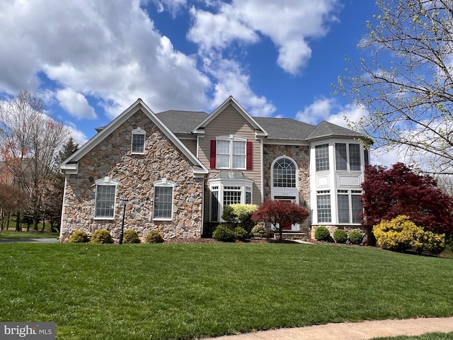 traditional home featuring a front yard and a shingled roof