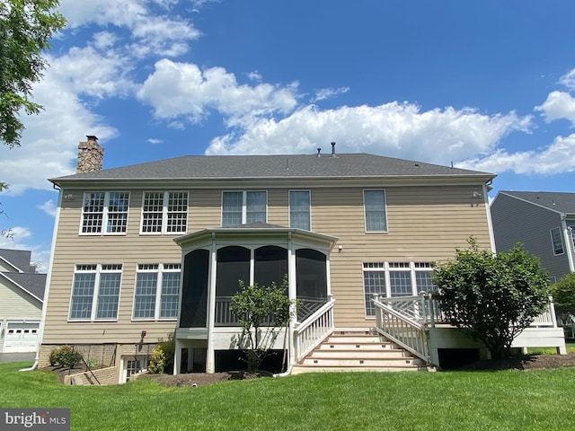 back of house featuring a lawn, a sunroom, and a chimney