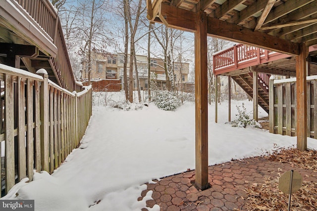 yard layered in snow with a deck