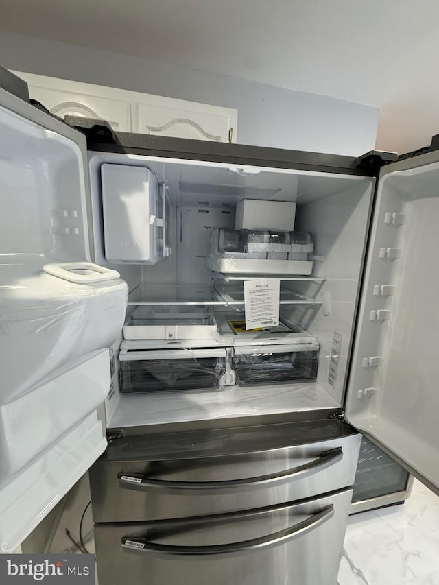 room details with refrigerator and white cabinets