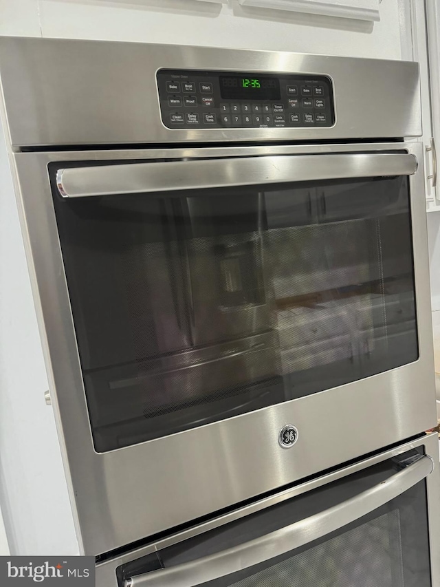 details with white cabinetry, double oven, and a mail area