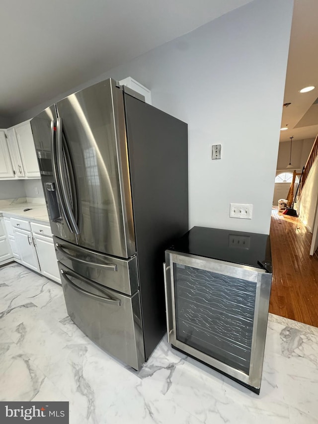 kitchen with white cabinets and stainless steel fridge with ice dispenser