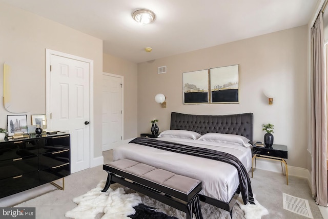 bedroom featuring baseboards, visible vents, and light colored carpet