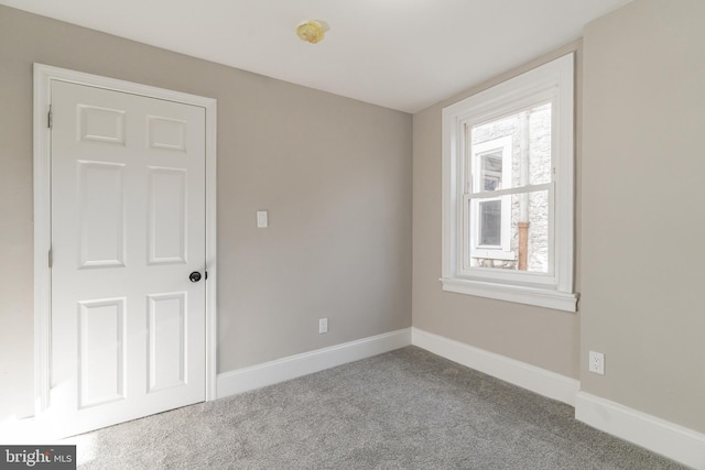 unfurnished room with light carpet and baseboards