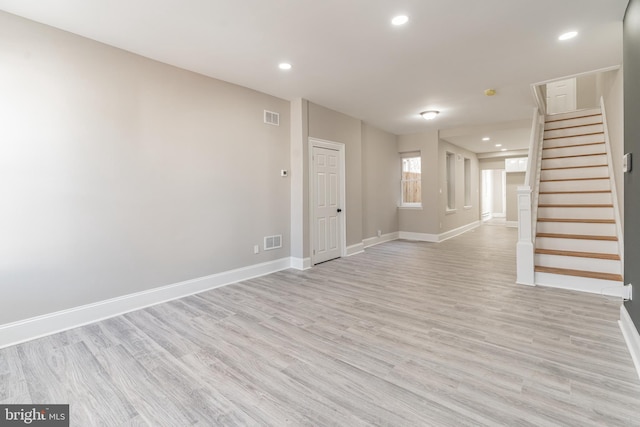 empty room with stairs, visible vents, and baseboards