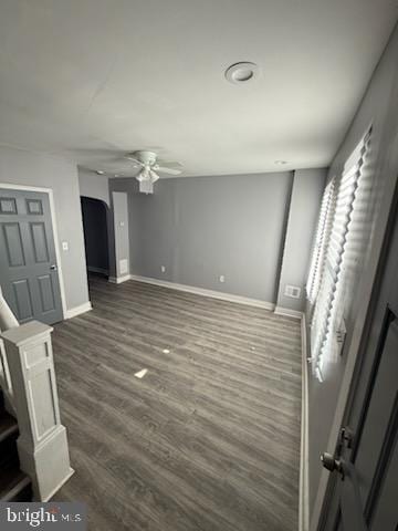 unfurnished living room with dark hardwood / wood-style floors and ceiling fan