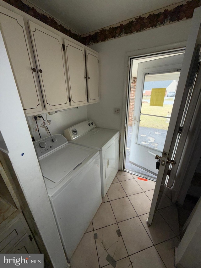 clothes washing area with washing machine and dryer and cabinets