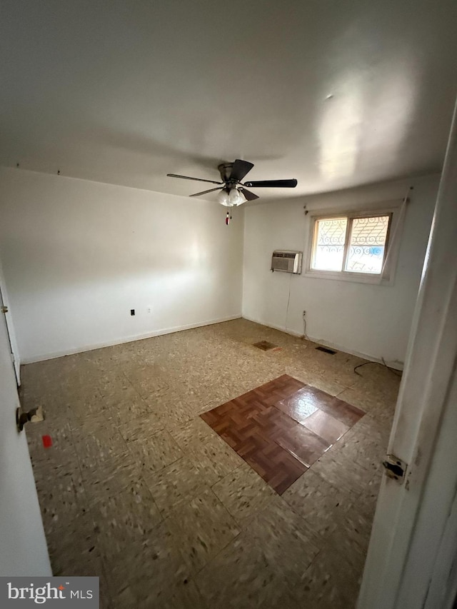 spare room featuring ceiling fan and a wall unit AC