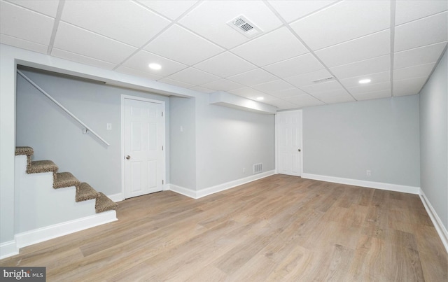 basement featuring light hardwood / wood-style flooring and a drop ceiling