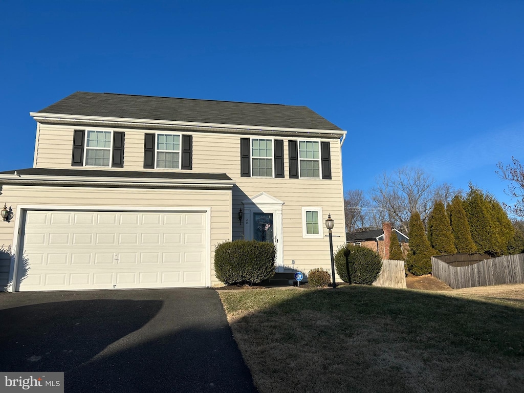 view of front of house with a garage and a front lawn