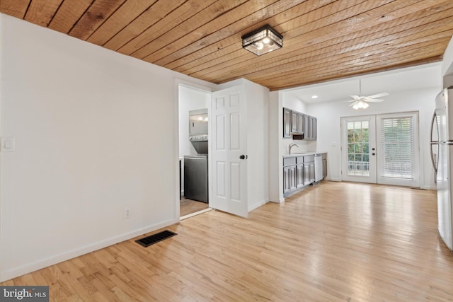 unfurnished living room with sink, ceiling fan, wooden ceiling, light wood-type flooring, and french doors