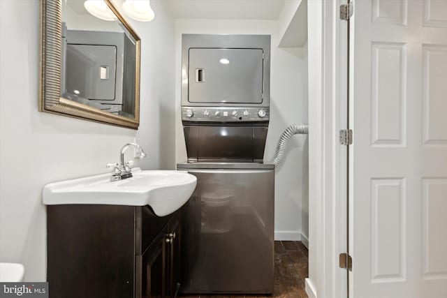 bathroom featuring vanity, hardwood / wood-style floors, and stacked washer / dryer