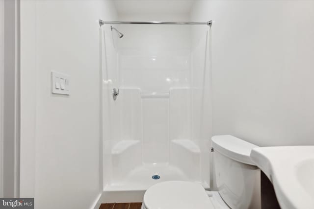 bathroom with vanity, toilet, hardwood / wood-style floors, and a shower