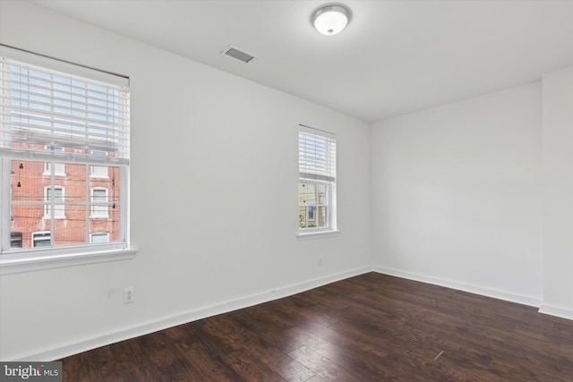 spare room with dark hardwood / wood-style floors