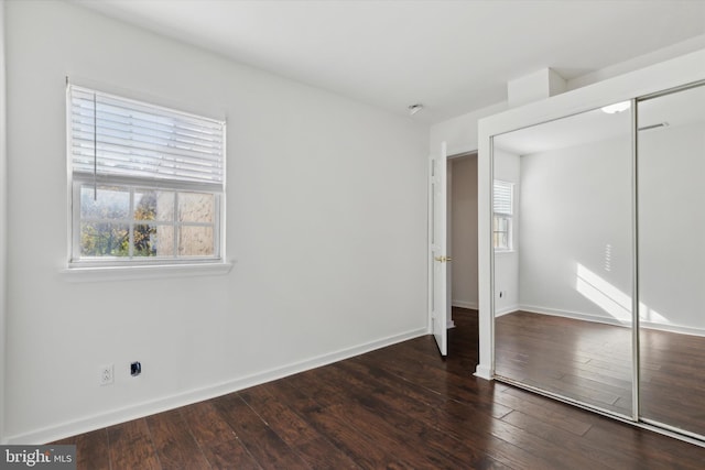 unfurnished bedroom featuring dark hardwood / wood-style floors and a closet