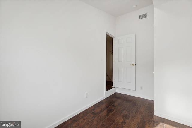 unfurnished room with dark wood-type flooring