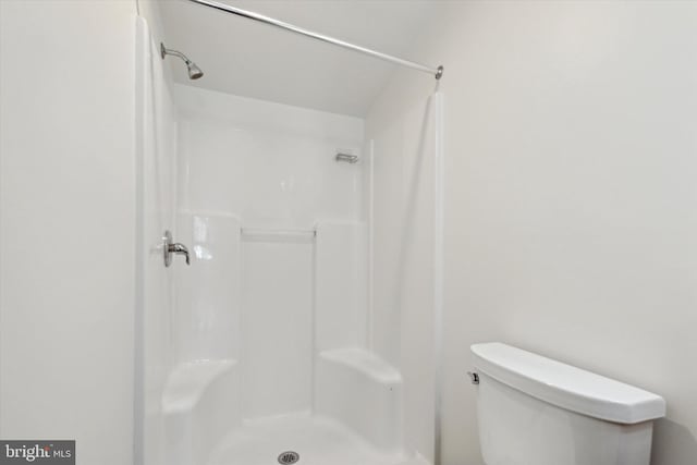 bathroom featuring walk in shower and toilet