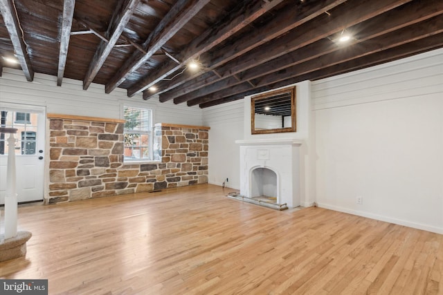 unfurnished living room featuring wooden ceiling, beamed ceiling, and light wood-type flooring