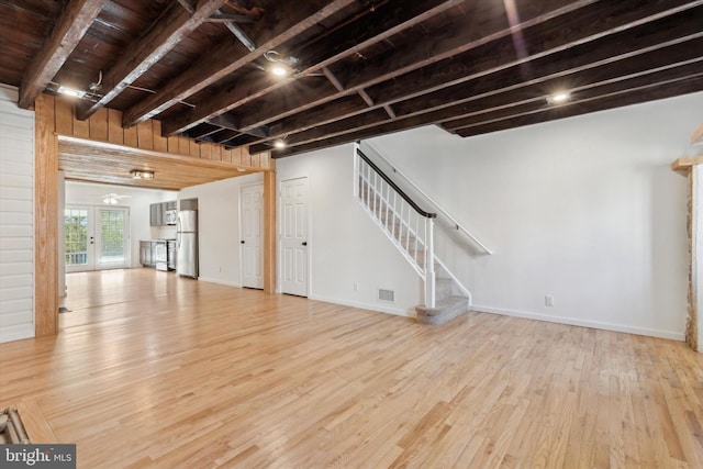 basement with light wood-type flooring, wooden ceiling, stainless steel refrigerator, and french doors