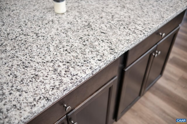 details with light stone countertops and dark brown cabinets