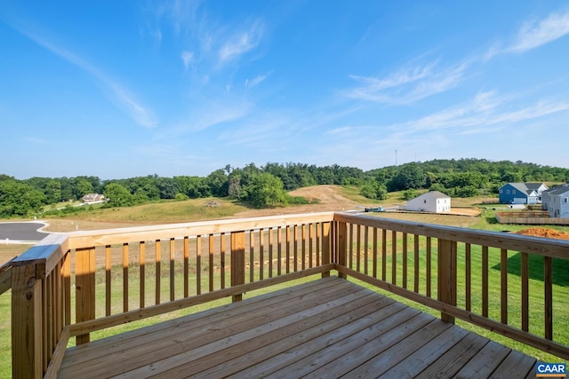 wooden terrace with a storage shed and a yard