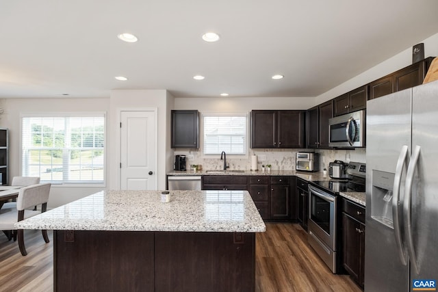 kitchen with dark brown cabinetry, appliances with stainless steel finishes, and a center island