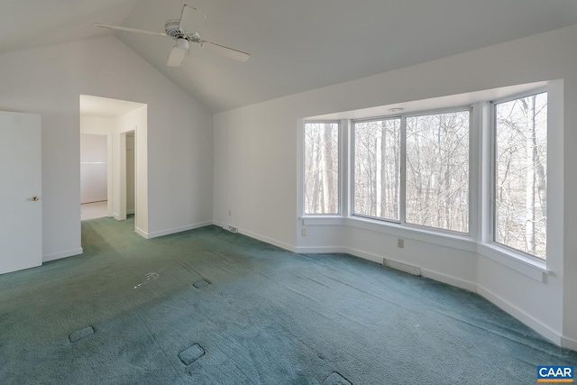 carpeted empty room with a wealth of natural light, ceiling fan, and vaulted ceiling