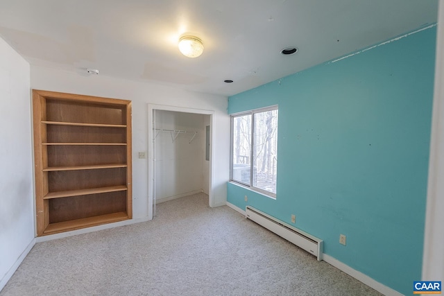 unfurnished bedroom with light colored carpet, baseboard heating, and a closet