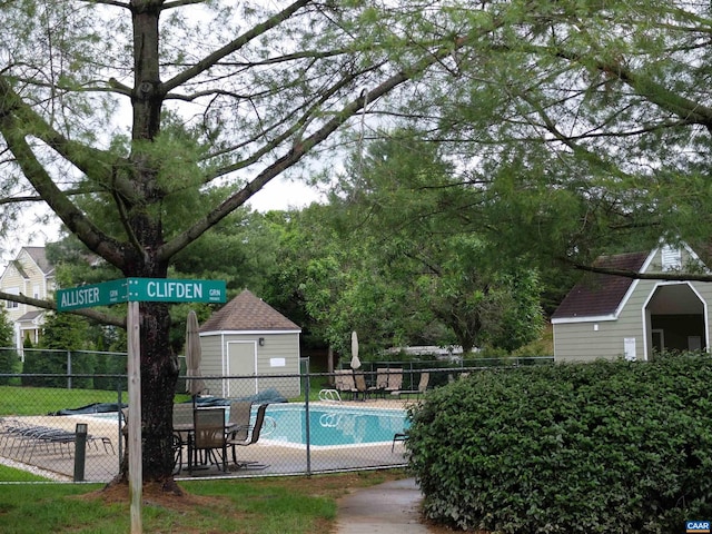 view of pool featuring a storage shed and a patio area