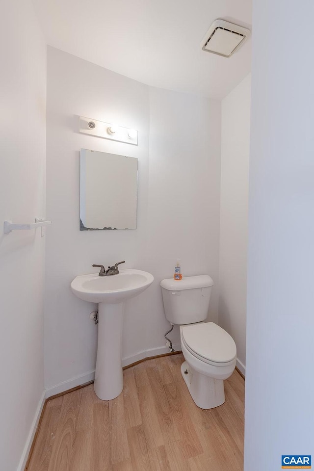 bathroom featuring wood-type flooring and toilet