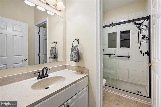 bathroom with vanity, tile patterned flooring, a shower with shower door, and toilet