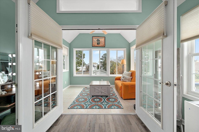 sunroom featuring lofted ceiling and french doors