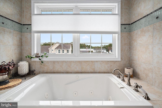 bathroom featuring plenty of natural light and tiled bath