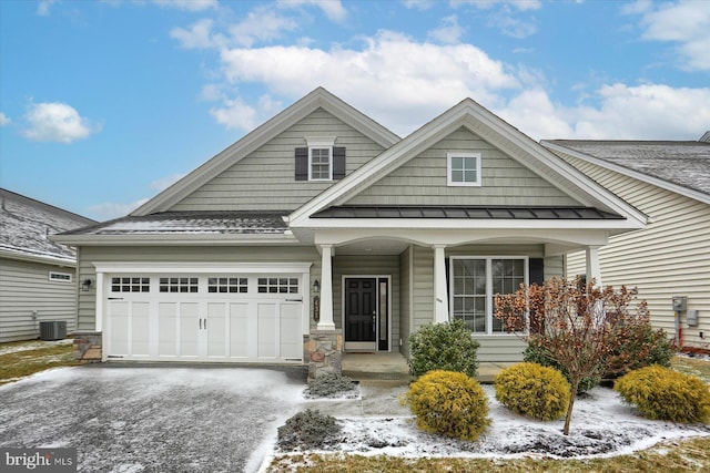 view of front of property with a garage and central air condition unit