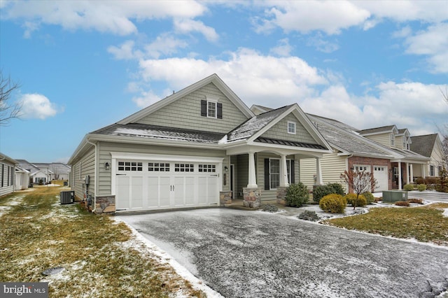 view of front of property featuring a garage, a porch, and central AC unit