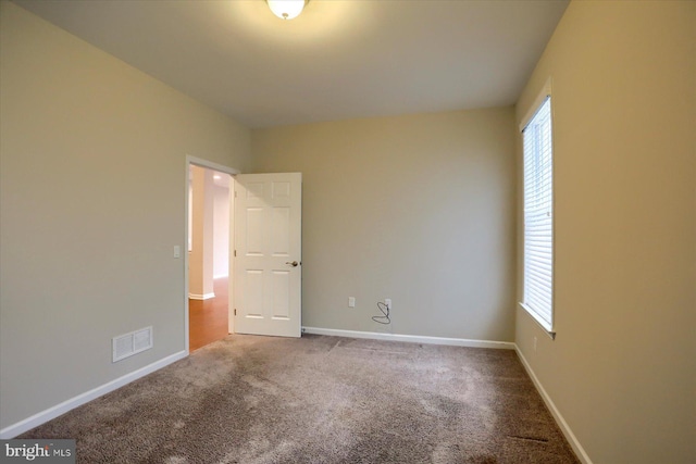 carpeted spare room featuring a healthy amount of sunlight