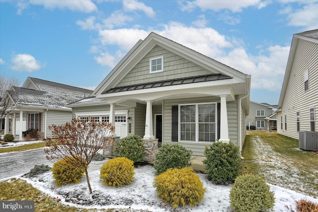 view of front of home with central AC, a porch, and a garage