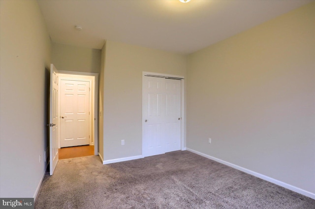 unfurnished bedroom featuring a closet and light carpet