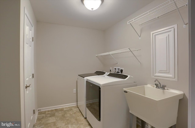 clothes washing area with independent washer and dryer and sink