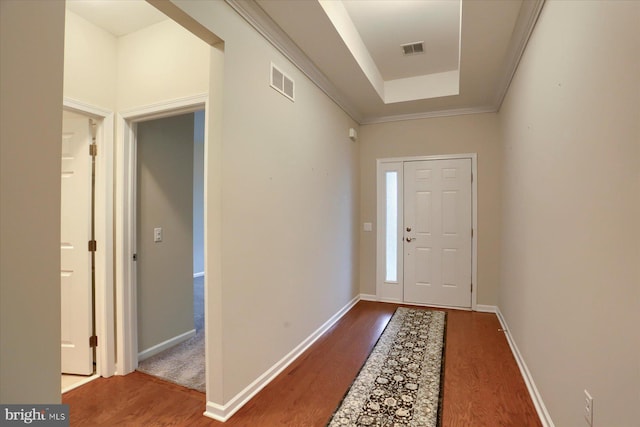 foyer featuring ornamental molding, hardwood / wood-style floors, and a tray ceiling