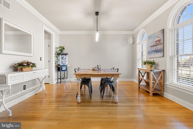 dining room featuring crown molding and light hardwood / wood-style floors