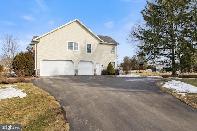 view of home's exterior with a garage and a playground