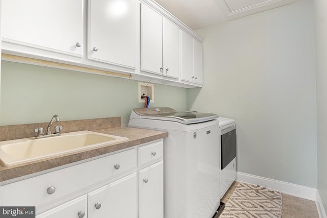 washroom with cabinets, separate washer and dryer, and sink