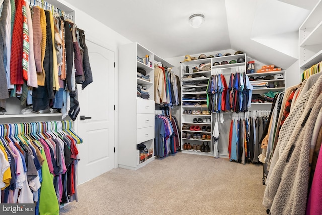 walk in closet featuring vaulted ceiling and light carpet