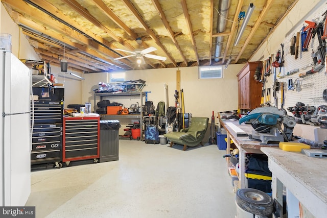 basement with a workshop area and white fridge