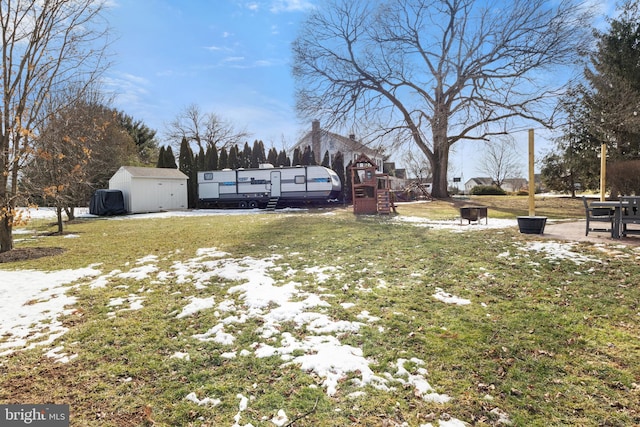 snowy yard with a storage shed