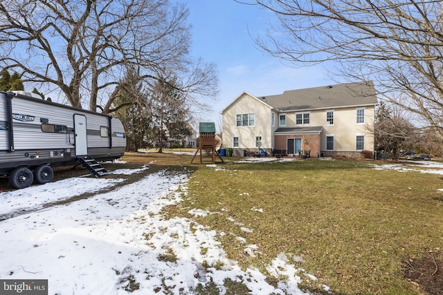 snow covered property featuring a lawn and a playground