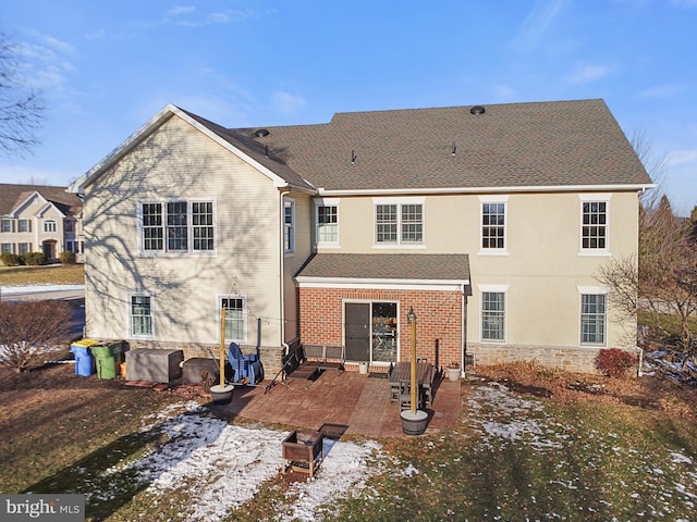 snow covered property with a patio