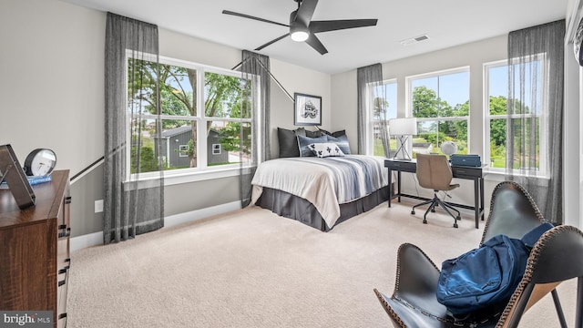 bedroom featuring multiple windows, ceiling fan, and carpet flooring